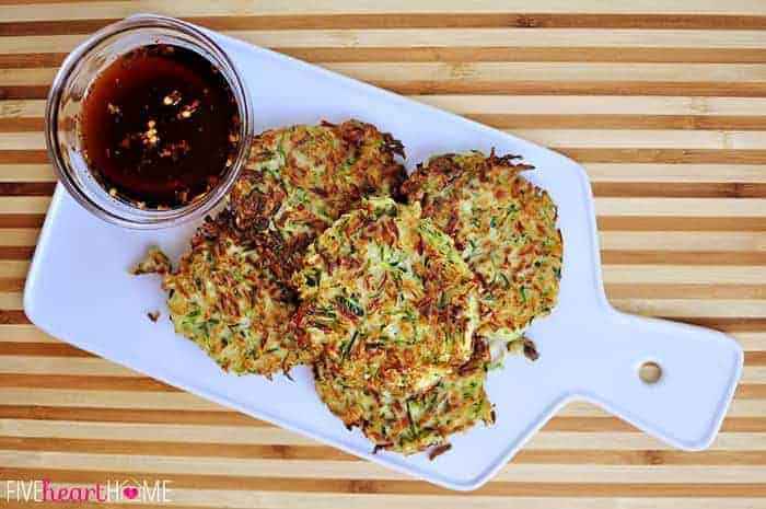 Zucchini Fritters ~ these golden, delicious fritters are crispy on the outside, creamy on the inside, and accompanied by a sweet and salty, Asian-inspired dipping sauce! | FiveHeartHome.com Aerial view of Zucchini Fritters with Asian Dipping Sauce on a board