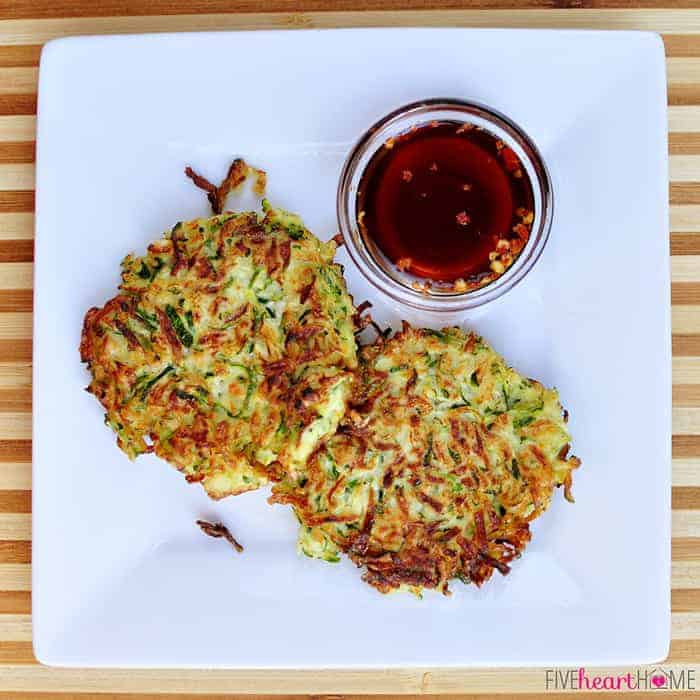 Aerial view of two Zucchini Fritters and small bowl of Asian Dipping Sauce on a square plate