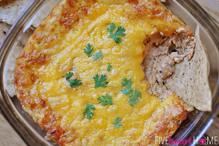 Chicken Enchilada Dip ~ a creamy, zesty dip loaded with chicken, cream cheese, cheddar, green chiles, and seasonings for a melty, delicious, gameday snack! | FiveHeartHome.com aerial view of Chicken Enchilada Dip with chip stuck in corner