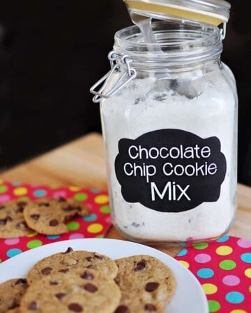 Jar of Chocolate Chip Cookie Mix with plate of fresh cookies.