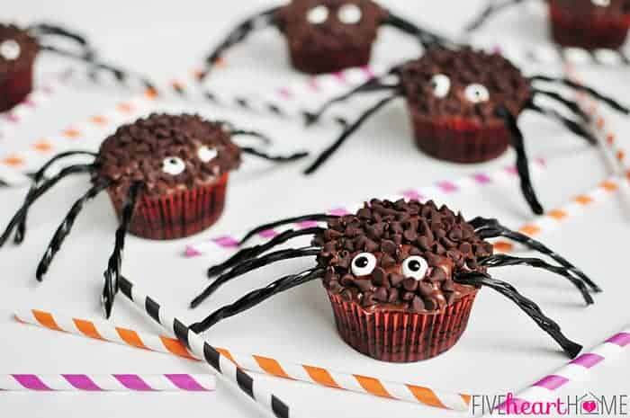 Spider Cupcakes on a table with striped paper straws in Halloween colors