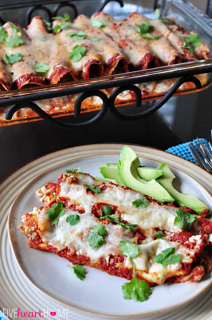 Creamy Chicken Enchiladas on plate garnished with avocado slices.