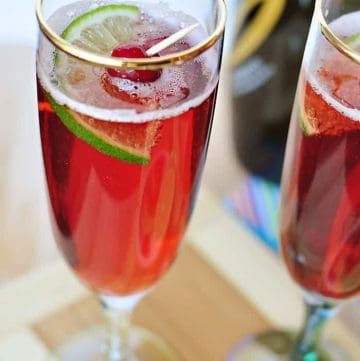Cranberry Pomegranate Bellini with garnish in gold-rimmed glass.