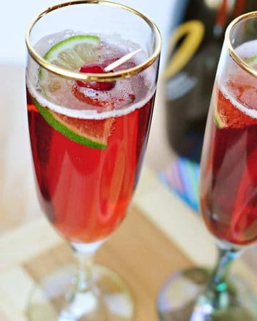 Cranberry Pomegranate Bellini with garnish in gold-rimmed glass.
