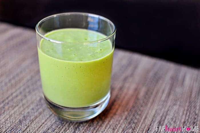 In a glass packed with fruit, creamy avocado, and vitamin-rich spinach for a creamy green color 