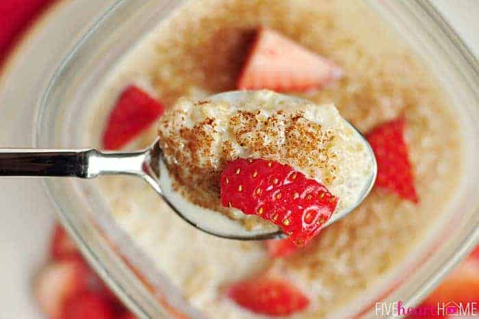 Aerial view of a spoonful of Quinoa Pudding, sprinkled with cinnamon and with a strawberry on top