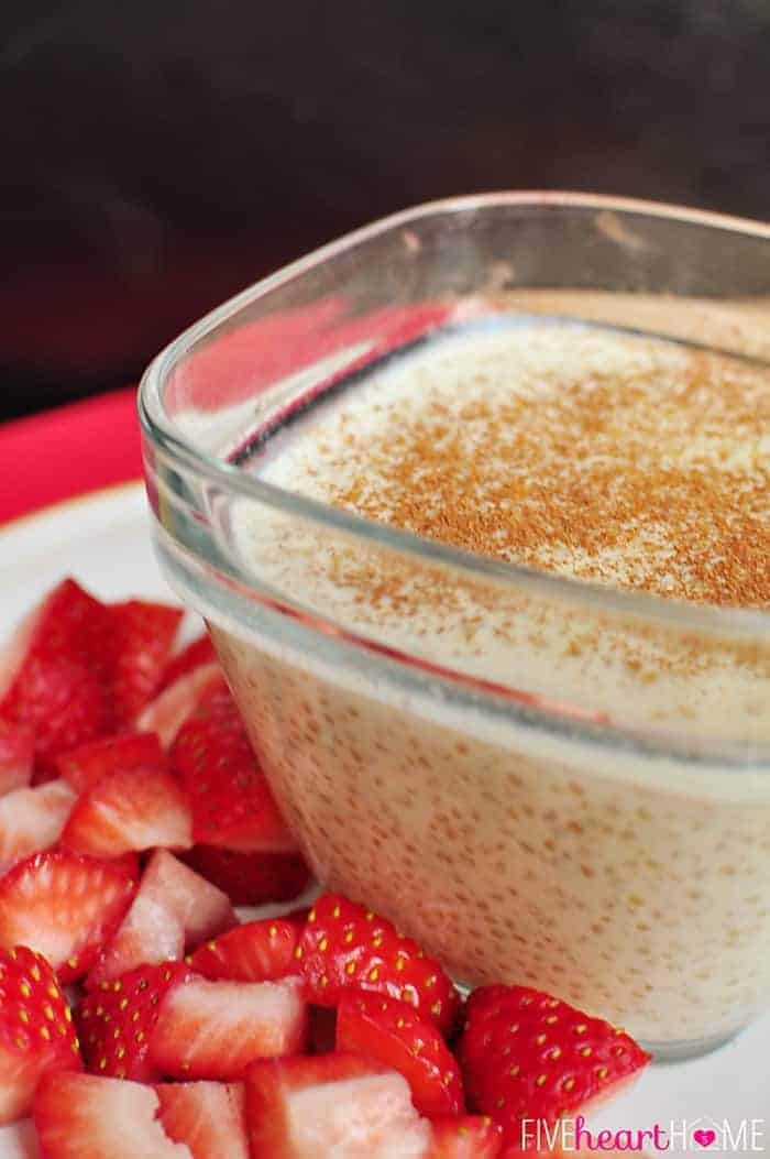Close-up photo of a clear glass bowl of Quinoa Pudding with cinnamon sprinkled on top