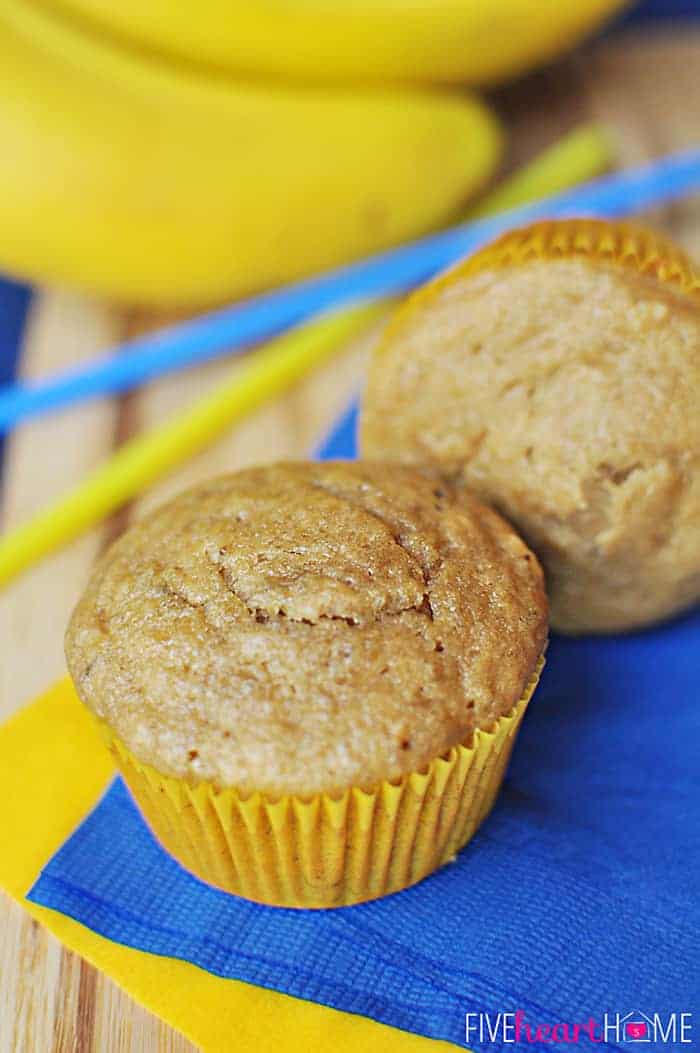 Healthy Banana Muffins ~ these muffins are delicious and wholesome, boasting healthy ingredients including whole wheat flour, coconut oil, yogurt, and honey! | FiveHeartHome.com Two Healthy Banana Muffins on blue and yellow napkins.