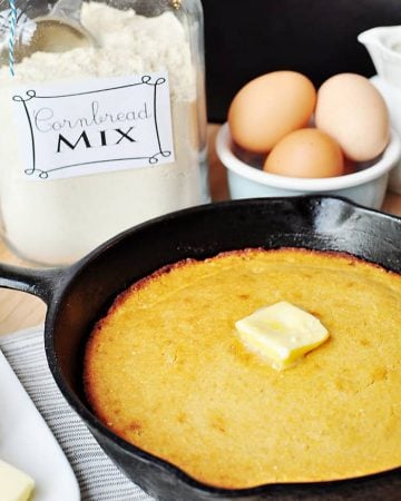 Cast iron skillet of cornbread with pat of butter on top