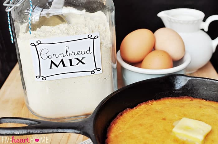 Cornbread Mix in a glass jar plus skillet of baked cornbread and bowl of eggs in background