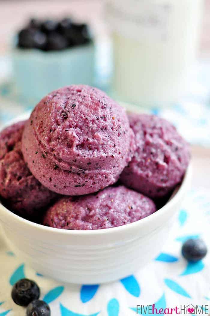 Close-Up of Scoops in a White Bowl with a Bowl of Fresh Blueberries in the Background 