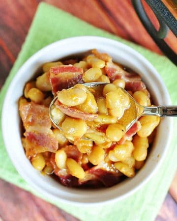 Aerial view of Southern Baked Beans in bowl with spoon.