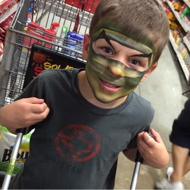 Child in grocery store with face painting.