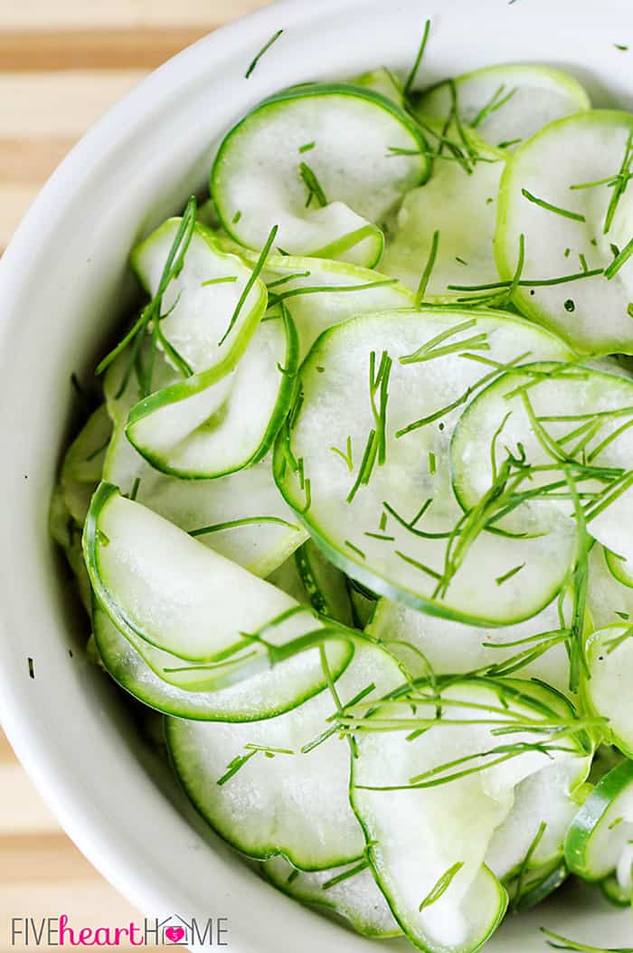 Tangy Cucumber Salad with Fresh Dill ~ thinly-sliced cucumbers in a simple, sweet-and-sour dressing make for a refreshing summer side | FiveHeartHome.com Aerial View of Tangy Cucumber Salad with Fresh Dill in White Bowl