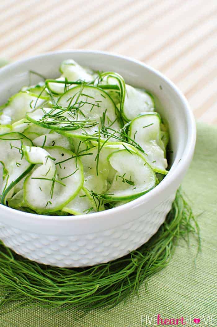 Tangy Cucumber Salad with Fresh Dill Served in a White Bowl on a Nest of Decorative Dill 