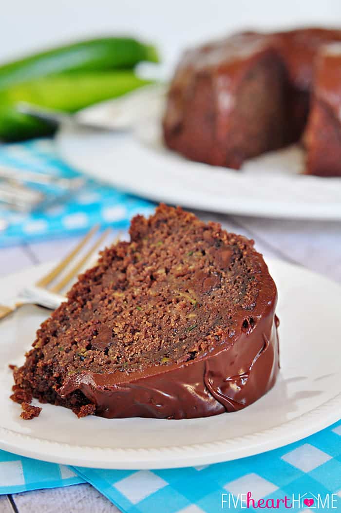 Chocolate Zucchini Bundt Cake with Chocolate Glaze {OR} Chocolate Zucchini Bread ~ so moist and decadent, nobody will guess that it's hiding a pound of zucchini and whole wheat flour! | FiveHeartHome.com Slice of Chocolate Zucchini Bundt Cake on white plate.