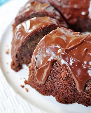 Sliced Chocolate Zucchini Bundt Cake with Chocolate Glaze on platter.