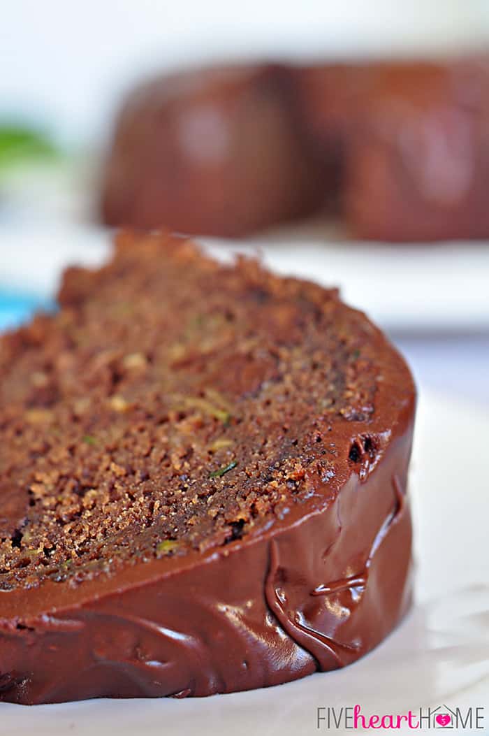 Chocolate Zucchini Bundt Cake with Chocolate Glaze {OR} Chocolate Zucchini Bread ~ so moist and decadent, nobody will guess that it's hiding a pound of zucchini and whole wheat flour! | FiveHeartHome.com Close-up of slice of Chocolate Zucchini Bundt Cake on plate.