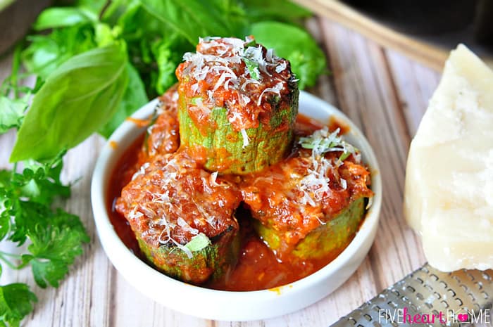 White dish with a serving of zucchini in tomato sauce.