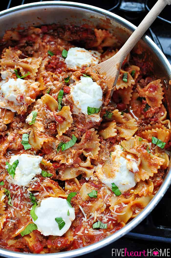 Wooden spoon scooping up pasta and ricotta.