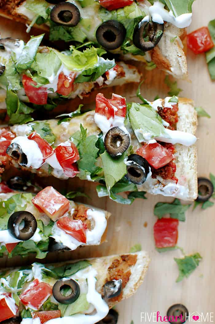 French Bread Taco Pizza ~ tacos meet pizza on an effortless French bread crust, with layers of refried beans, salsa, taco meat, cheese, lettuce, tomatoes, black olives, and sour cream! | FiveHeartHome.com Aerial View