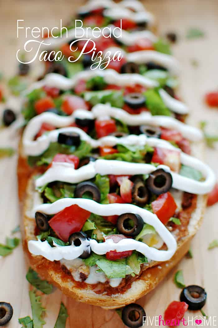 French Bread Taco Pizza ~ tacos meet pizza on an effortless French bread crust, with layers of refried beans, salsa, taco meat, cheese, lettuce, tomatoes, black olives, and sour cream! | FiveHeartHome.com via @fivehearthome