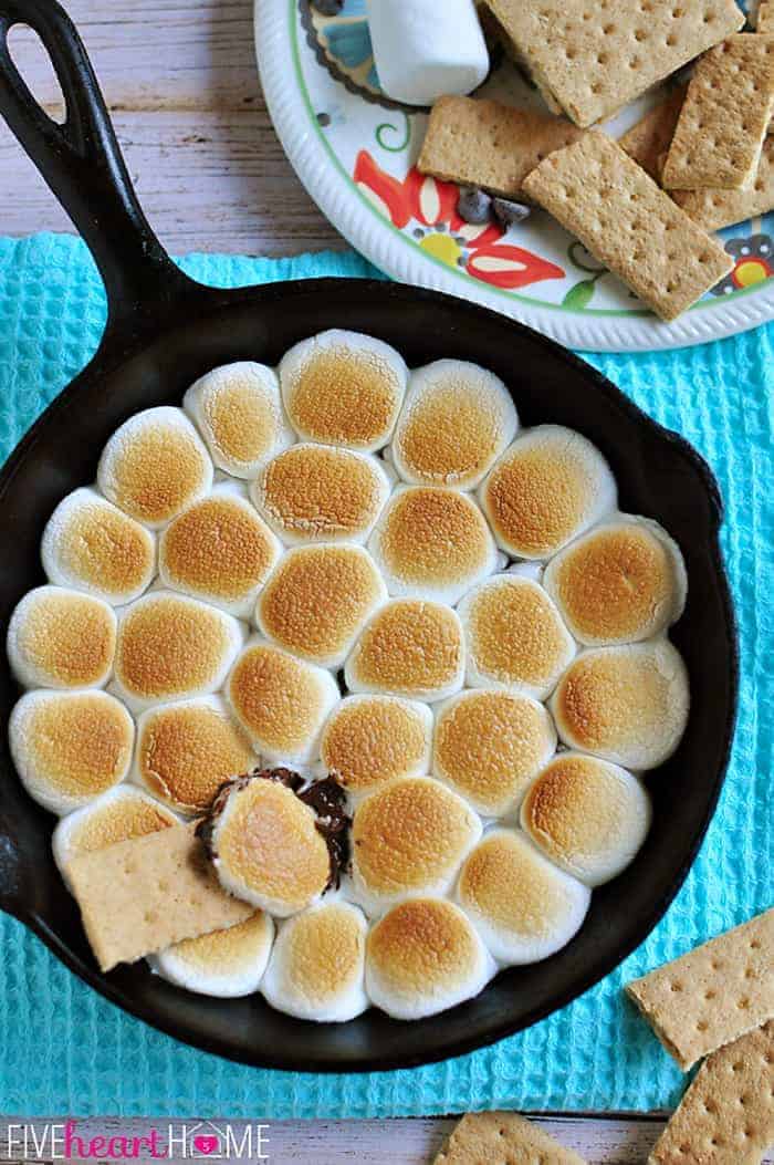 S'mores Dip ~ melted chocolate and toasty marshmallows bake up in a skillet; scoop up with graham crackers for a perfect party dessert! | FiveHeartHome.com