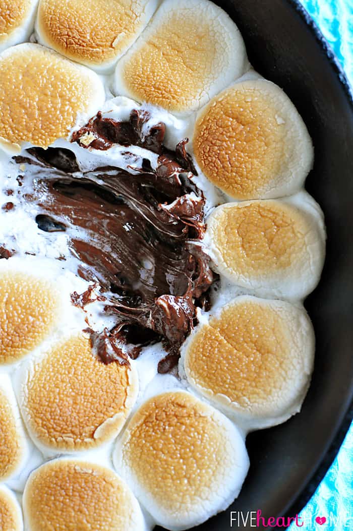 S'mores Dip ~ melted chocolate and toasty marshmallows bake up in a skillet; scoop up with graham crackers for a perfect party dessert! | FiveHeartHome.com Aerial view of Smores Dip with marshmallows missing.