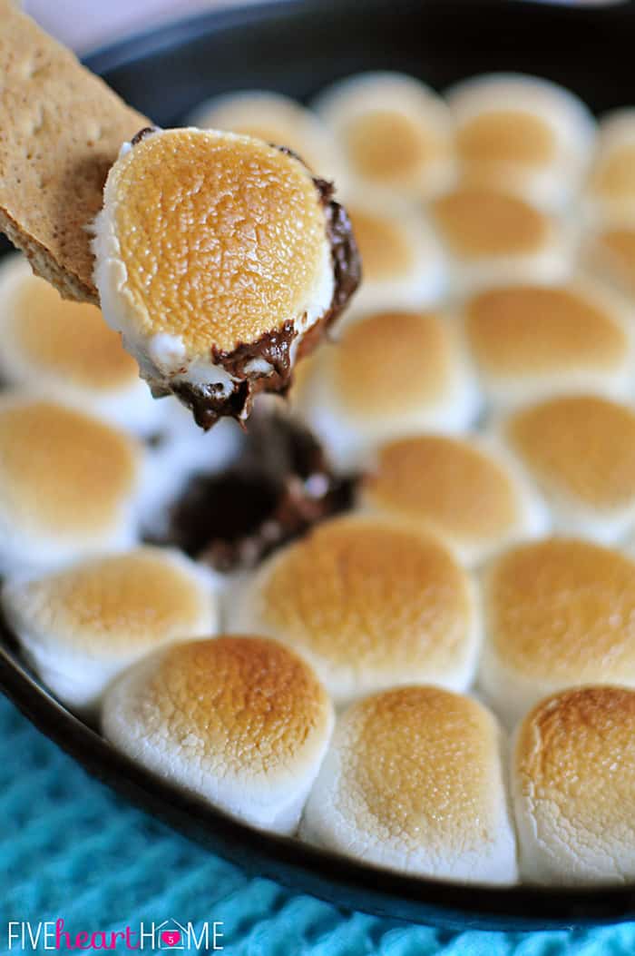 S'mores Dip ~ melted chocolate and toasty marshmallows bake up in a skillet; scoop up with graham crackers for a perfect party dessert! | FiveHeartHome.com