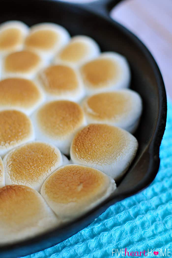 S'mores Dip ~ melted chocolate and toasty marshmallows bake up in a skillet; scoop up with graham crackers for a perfect party dessert! | FiveHeartHome.com Smores Dip zoom with toasted marshmallows.