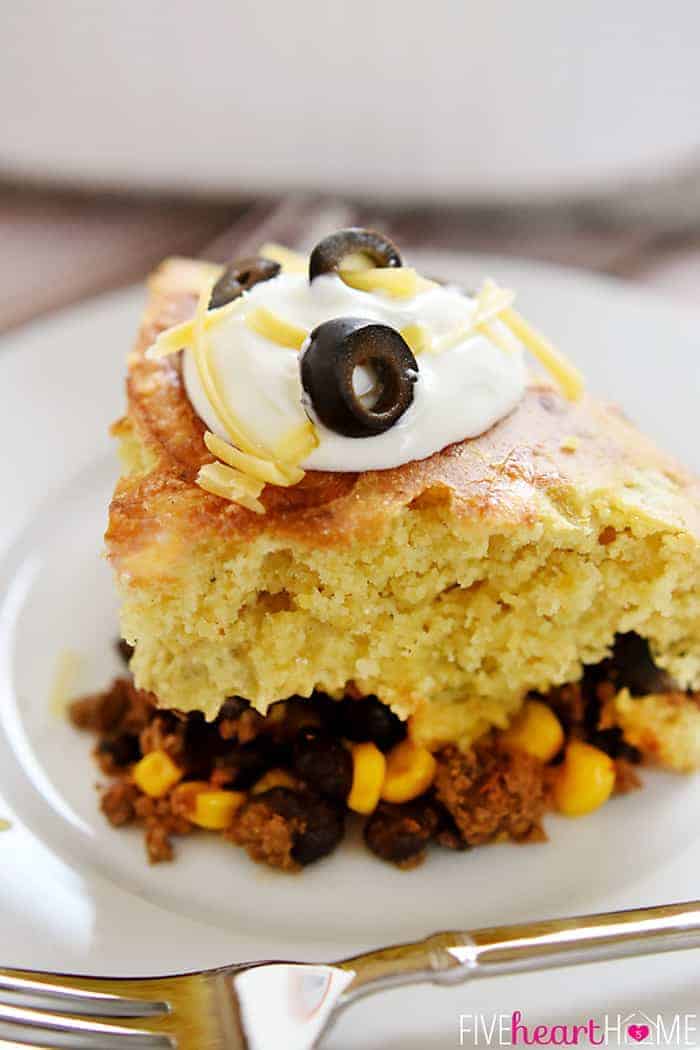 Mexican Cornbread Casserole topped with sour cream, cheddar, and black olives.