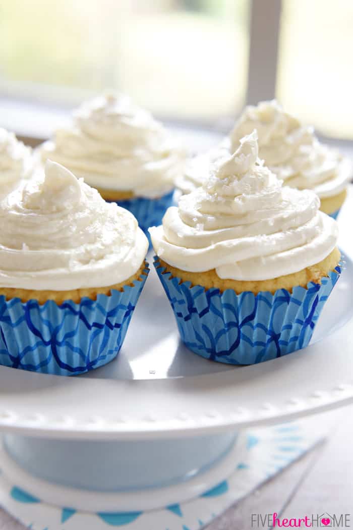 Several Cupcakes on White Pedestal with Blue Paper Liners and Perfectly Swirled Buttercream 