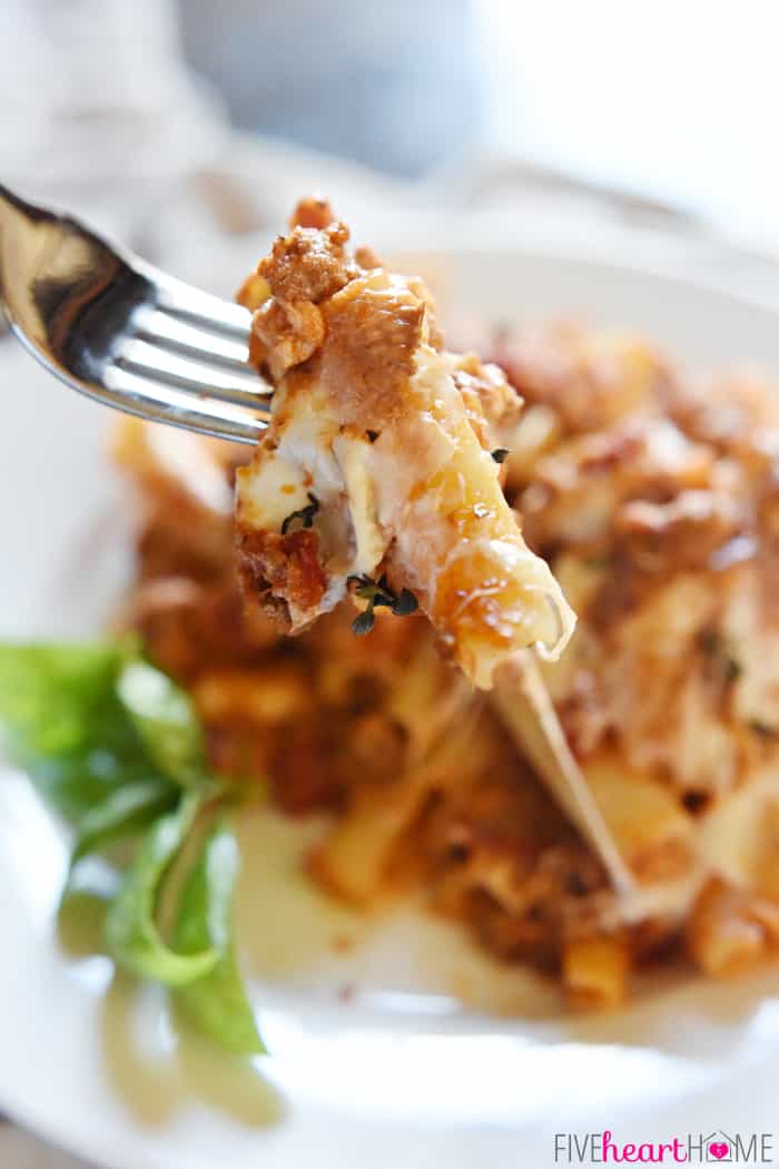Baked Ziti ~ easy to make and oozing with cheese, this pasta dish is comfort food perfection! | FiveHeartHome.com Stabbed Bite of Baked Ziti on a Silver Fork