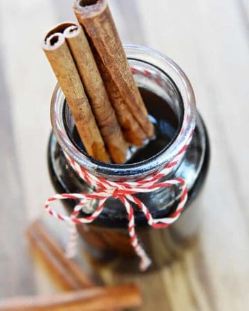 Homemade Cinnamon Syrup in glass jar with cinnamon sticks.