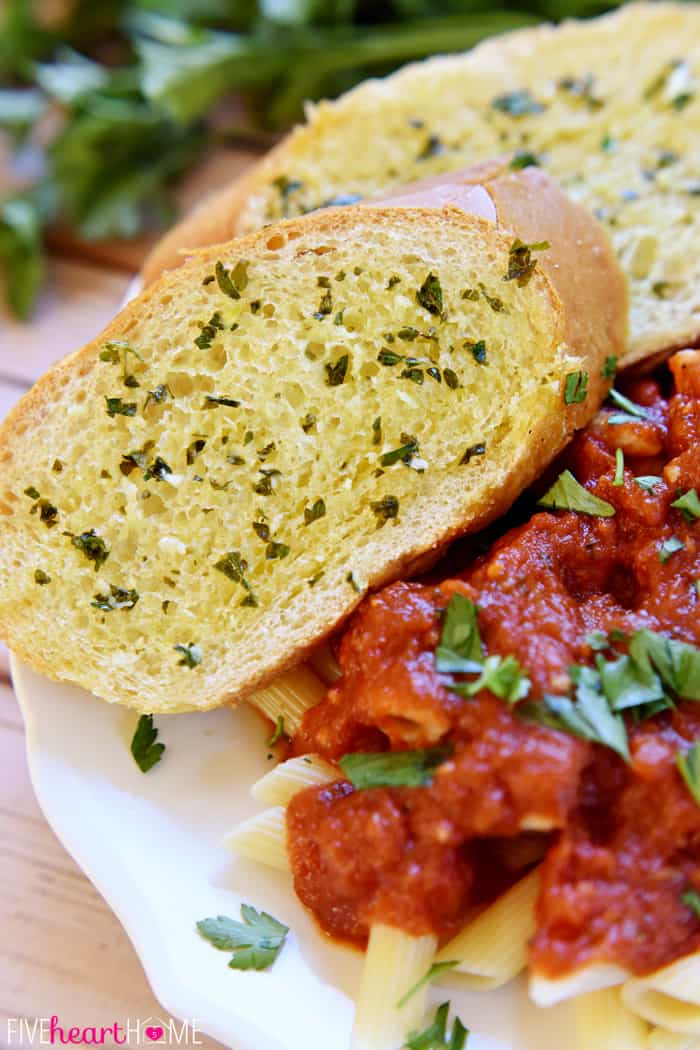 Garlic Bread with Fresh Garlic and Parsley Served Alongside Pasta 