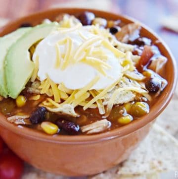 Slow Cooker Chicken Tortilla Soup ~ this effortless, hearty, taco-seasoned soup is brimming with chicken, beans, and corn and topped with crushed tortilla chips, sour cream, and grated cheddar...sure to become a fall and winter favorite! | FiveHeartHome.com