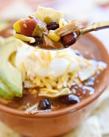 Slow Cooker Chicken Tortilla Soup ~ this effortless, hearty, taco-seasoned soup is brimming with chicken, beans, and corn and topped with crushed tortilla chips, sour cream, and grated cheddar...sure to become a fall and winter favorite! | FiveHeartHome.com