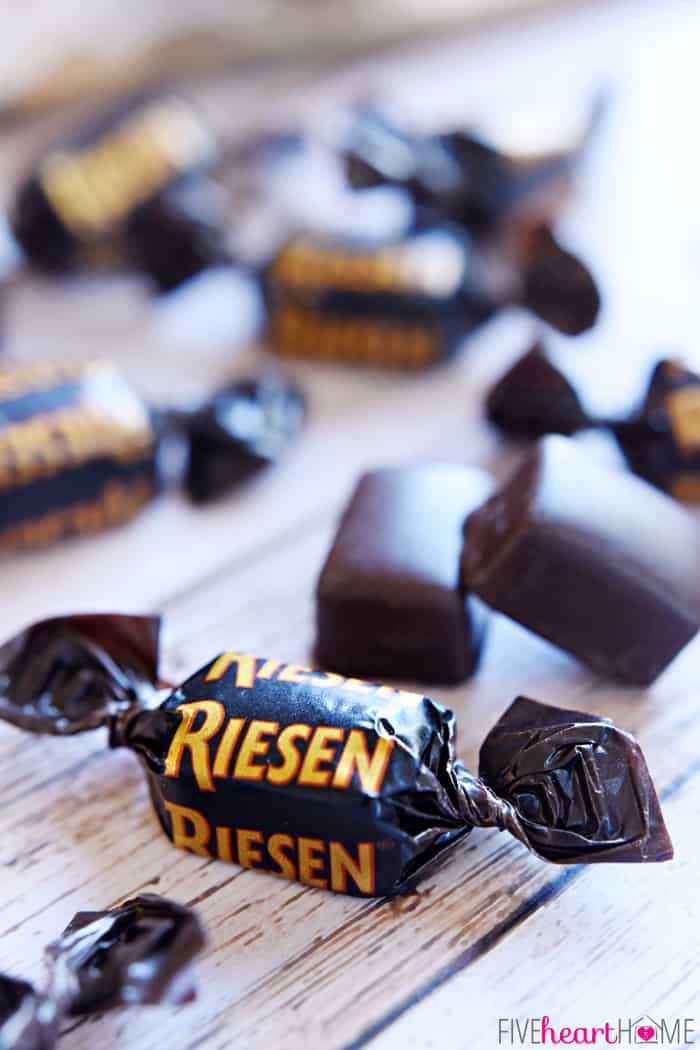 Wrapped and unwrapped Riesen caramel candies scattered on table