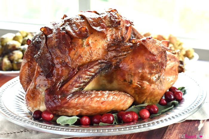 Maple-Glazed Turkey with Bacon and Sage Butter on Silver Platter with Fresh Cranberry Garnish 