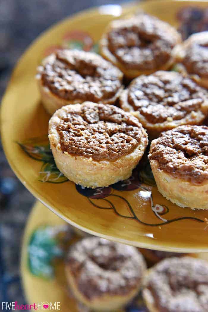 Mini Pecan Pies Piled on a Decorative Painted Plate Showcasing Crunchy Top and Flaky Crust 