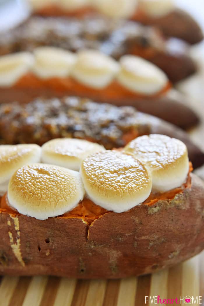 Twice-Baked Sweet Potatoes on wooden board topped with marshmallows and pecan streusel.