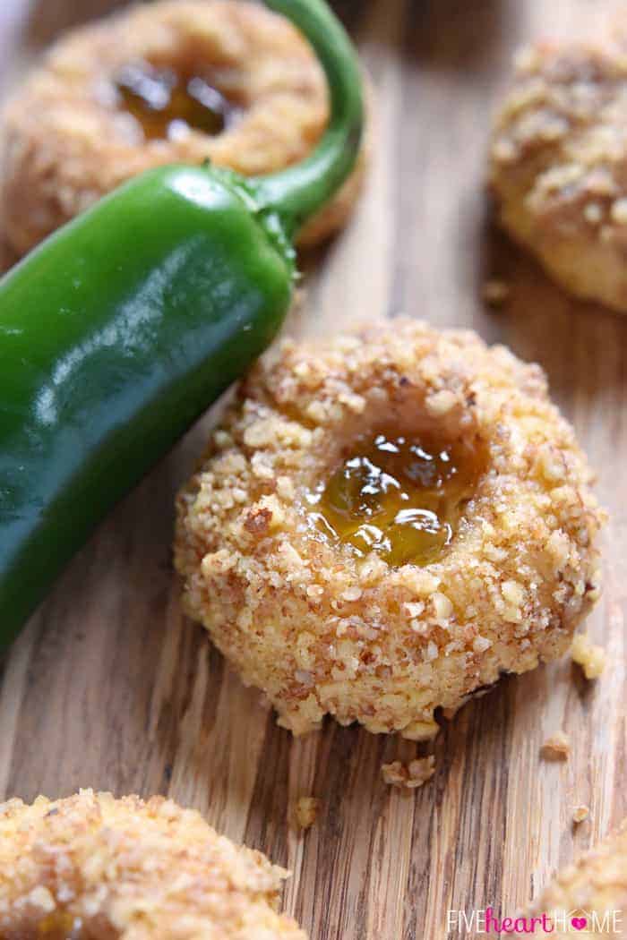 Cheddar Jalapeño Jelly Thumbprints on wooden cutting board with fresh jalapeño.