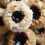 Close-up of Jam Thumbprint Cookies coated with nuts and coconut.