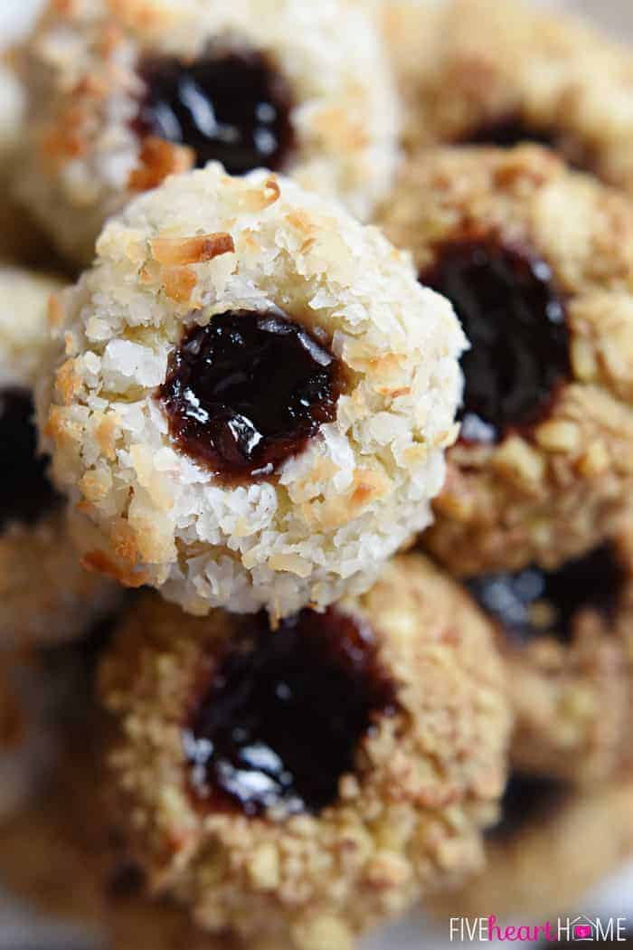 Close-up of Jam Thumbprint Cookies coated with nuts and coconut.