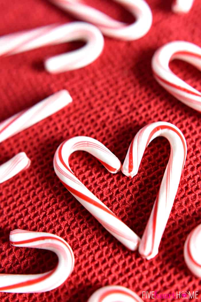 Peppermint candy canes formed into a heart on a red cloth.