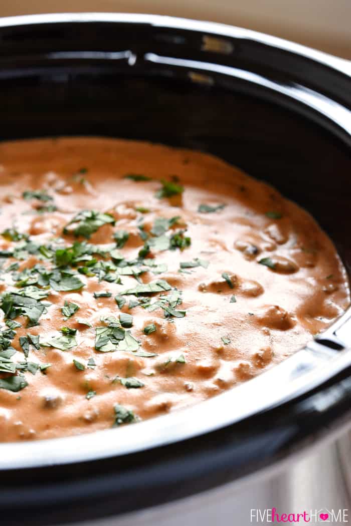 All-Natural Chili Cheese Dip ~ this decadent, creamy, real food version of Chili's Skillet Queso features homemade chili, cheddar cheese sauce, and no processed ingredients! | FiveHeartHome.com Close-up of Chili Cheese Dip staying warm in a slow cooker, garnished with fresh cilantro