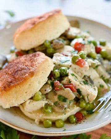 Chicken ala King over biscuits on plate.