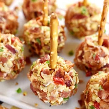 Tray of Pimento Cheese Mini Cheese Ball Bites with pretzel skewers.