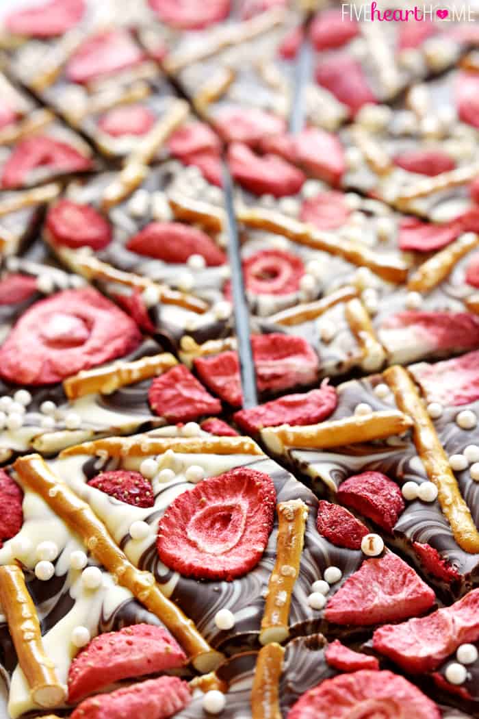 Close-up showing semi-sweet and white chocolate swirled together and topped with pretzels, freeze-dried strawberries, and white sprinkles