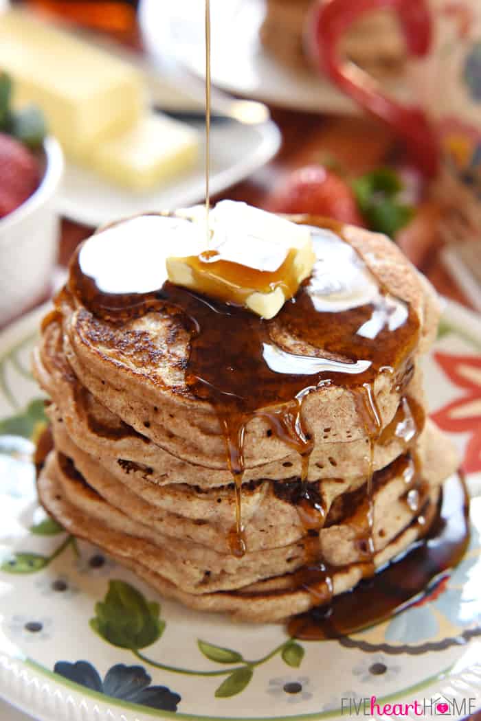 Syrup drizzling shortstack on floral plate.